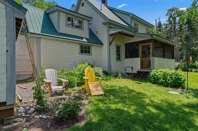 574 Mingo Loop Rd, Rangeley, ME 04970 - back of house featuring a sunroom, a lawn, and a metal roof