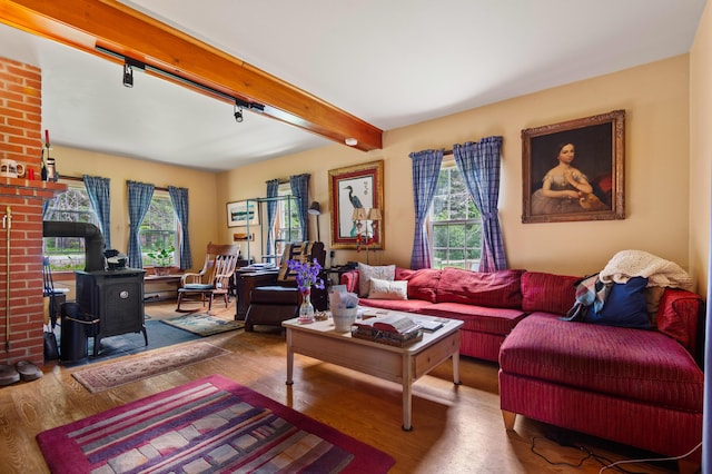 574 Mingo Loop Rd, Rangeley, ME 04970 - living area featuring a wood stove, wood finished floors, and beam ceiling