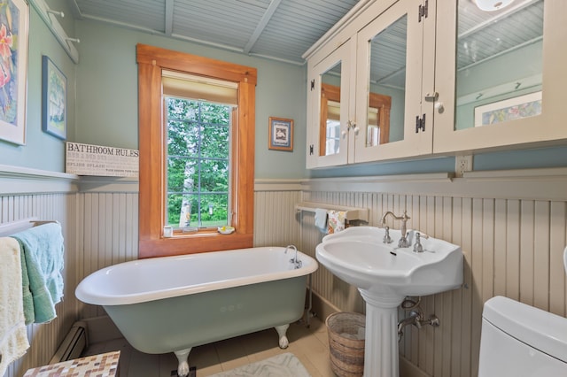 574 Mingo Loop Rd, Rangeley, ME 04970 - bathroom featuring a freestanding tub, a wainscoted wall, tile patterned floors, and baseboard heating