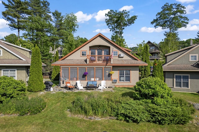 71 Village Way Unit 506, Edgecomb, ME 04556 - back of property featuring a balcony, a lawn, a sunroom, and a shingled roof