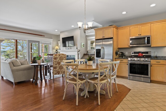 71 Village Way Unit 506, Edgecomb, ME 04556 - kitchen with stainless steel appliances, open floor plan, a fireplace, recessed lighting, and a chandelier