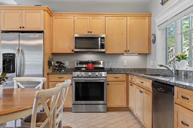 71 Village Way Unit 506, Edgecomb, ME 04556 - kitchen with appliances with stainless steel finishes, light brown cabinets, light tile patterned flooring, and dark stone counters