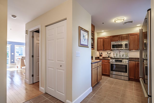 148 Breakwater Dr Unit 17, South Portland, ME 04106 - kitchen featuring appliances with stainless steel finishes, light tile patterned floors, brown cabinets, and recessed lighting