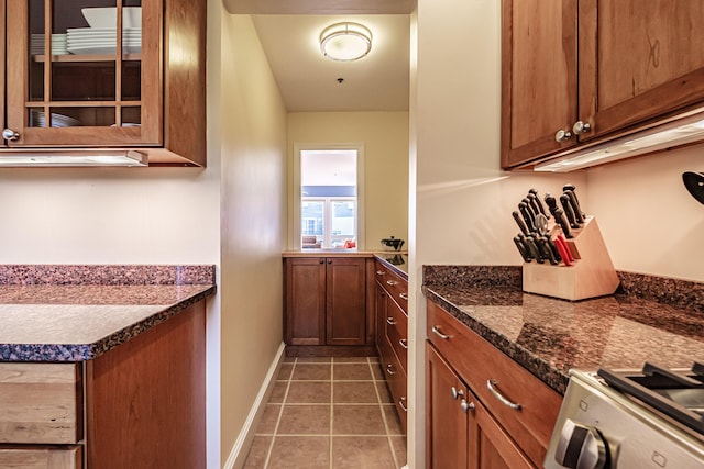 148 Breakwater Dr Unit 17, South Portland, ME 04106 - kitchen featuring glass insert cabinets, light tile patterned floors, brown cabinets, and stove