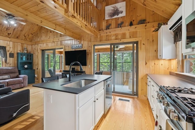 8 Log Cabin Ln Unit 9, Shapleigh, ME 04076 - kitchen featuring open floor plan, wooden walls, light wood finished floors, dark countertops, and stainless steel appliances