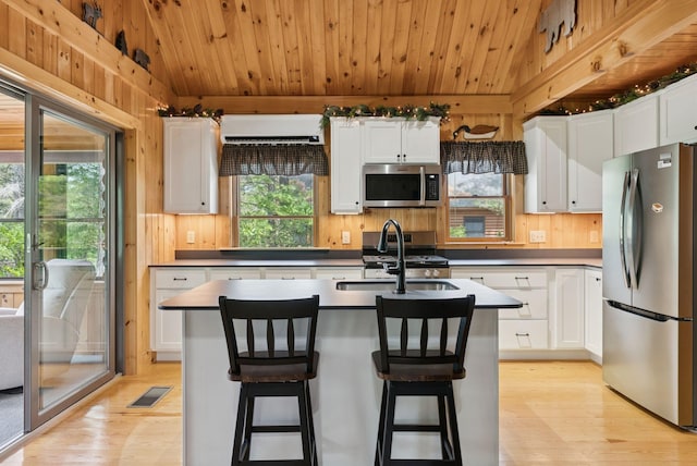 8 Log Cabin Ln Unit 9, Shapleigh, ME 04076 - kitchen featuring appliances with stainless steel finishes, light wood-type flooring, white cabinets, an island with sink, and wood ceiling