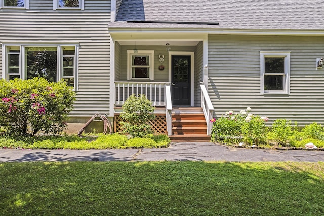 15 Harvey Brook Dr, Freeport, ME 04032 - doorway to property featuring covered porch, a shingled roof, and a yard
