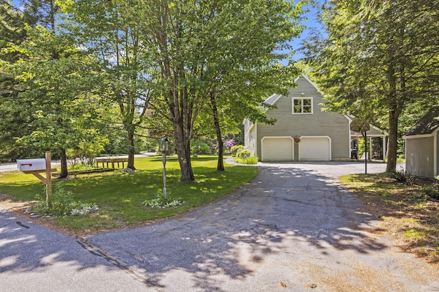 15 Harvey Brook Dr, Freeport, ME 04032 - view of property hidden behind natural elements featuring a garage, asphalt driveway, and a front lawn