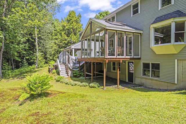 15 Harvey Brook Dr, Freeport, ME 04032 - back of house featuring a sunroom, a lawn, a deck, stairs, and a shingled roof