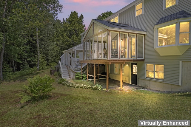 15 Harvey Brook Dr, Freeport, ME 04032 - back of house at dusk with stairs, a sunroom, a lawn, a wooden deck, and a shingled roof