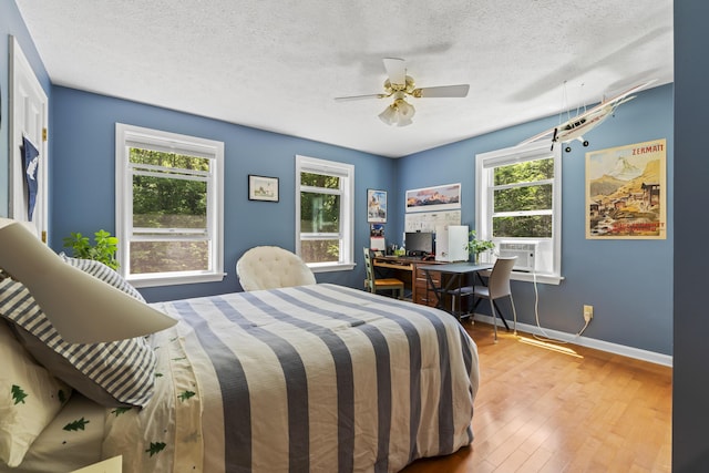 15 Harvey Brook Dr, Freeport, ME 04032 - bedroom featuring multiple windows, hardwood / wood-style flooring, a textured ceiling, a ceiling fan, and a desk