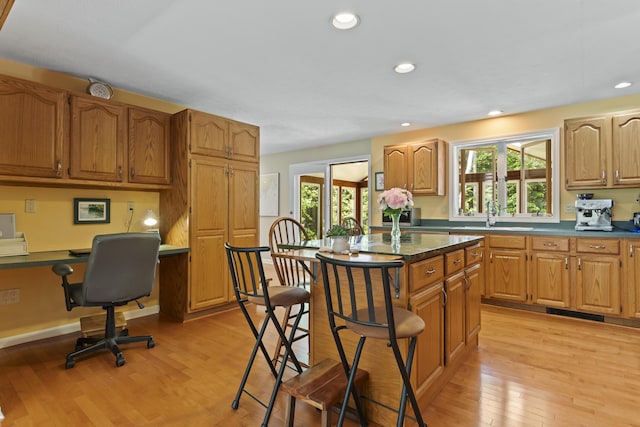 15 Harvey Brook Dr, Freeport, ME 04032 - kitchen with built in desk, light wood-type flooring, healthy amount of natural light, a breakfast bar, and recessed lighting