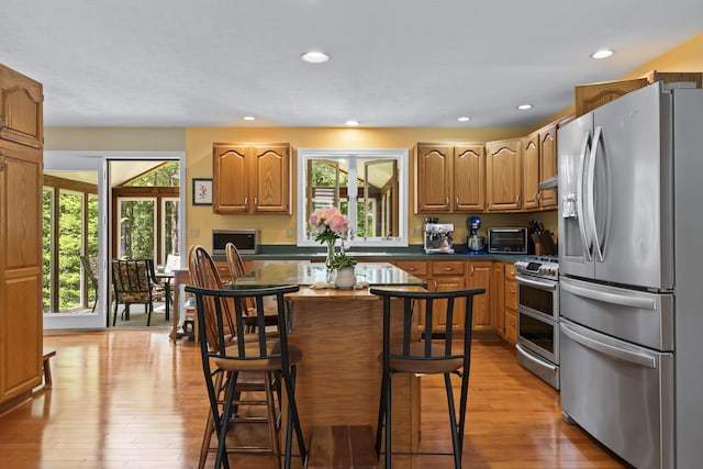 15 Harvey Brook Dr, Freeport, ME 04032 - kitchen featuring stainless steel appliances, light wood-style floors, dark countertops, recessed lighting, and a breakfast bar
