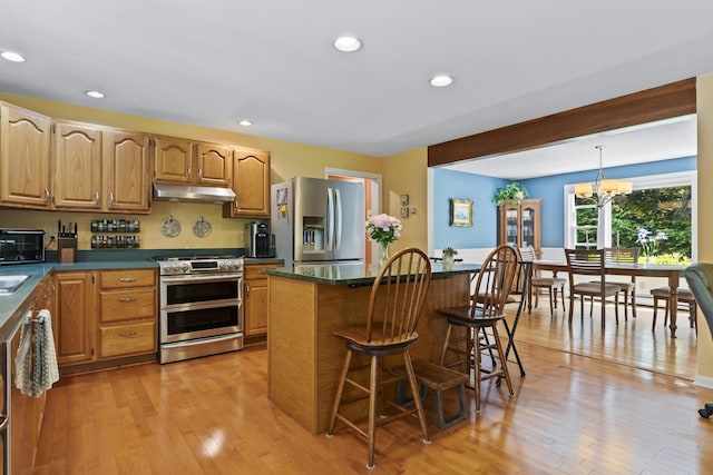 15 Harvey Brook Dr, Freeport, ME 04032 - kitchen featuring stainless steel appliances, under cabinet range hood, dark countertops, a kitchen bar, and recessed lighting