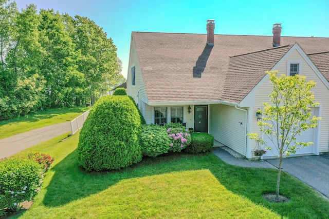 97 Dockside Ln Unit 8, Belfast, ME 04915 - view of front of home featuring an attached garage, a front lawn, a chimney, and a shingled roof
