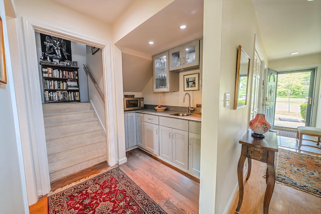 97 Dockside Ln Unit 8, Belfast, ME 04915 - indoor wet bar with stainless steel microwave, light wood-style floors, recessed lighting, and stairs