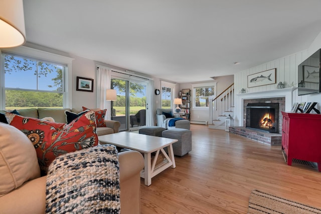 13 Norwood Ln, Kennebunkport, ME 04046 - living area with light wood-style floors, a baseboard radiator, stairs, and a brick fireplace