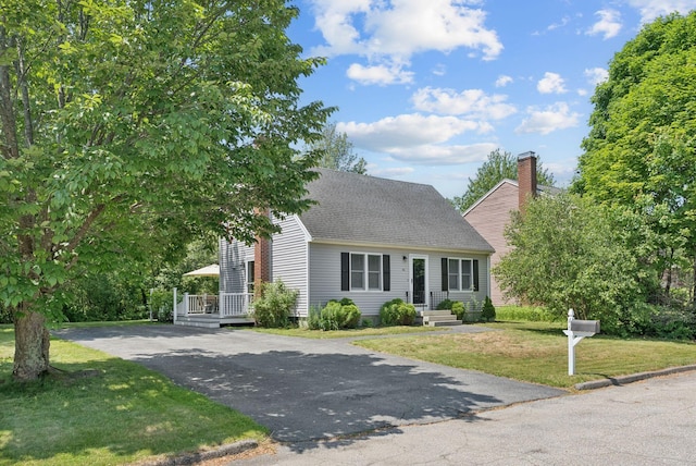 46 Label Ave, Portland, ME 04103 - cape cod home featuring asphalt driveway, a front lawn, roof with shingles, and a chimney