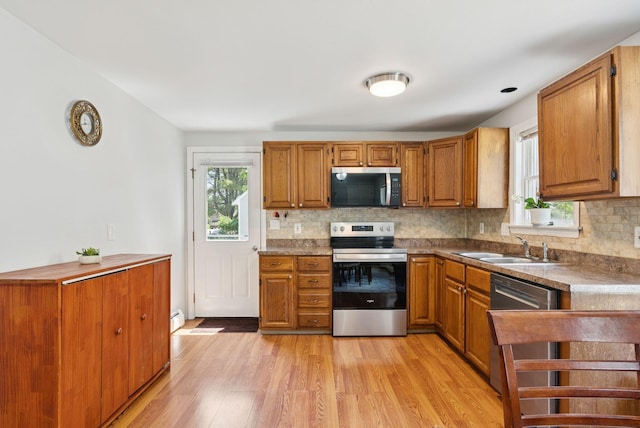 46 Label Ave, Portland, ME 04103 - kitchen with stainless steel appliances, plenty of natural light, backsplash, and brown cabinetry