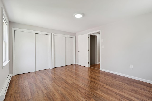46 Label Ave, Portland, ME 04103 - unfurnished bedroom with a baseboard radiator, multiple closets, and wood finished floors