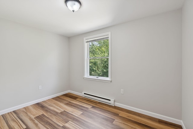 46 Label Ave, Portland, ME 04103 - empty room with a baseboard heating unit and wood finished floors
