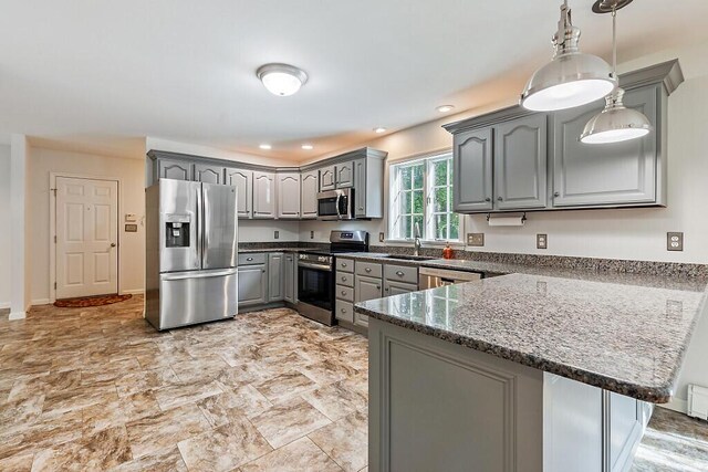 4 Acorn Ln, Lewiston, ME 04240 - kitchen featuring appliances with stainless steel finishes, gray cabinets, a peninsula, dark stone countertops, and hanging light fixtures