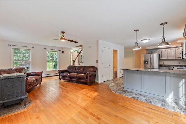 4 Acorn Ln, Lewiston, ME 04240 - living room featuring stairway, baseboard heating, ceiling fan, and light wood-style flooring