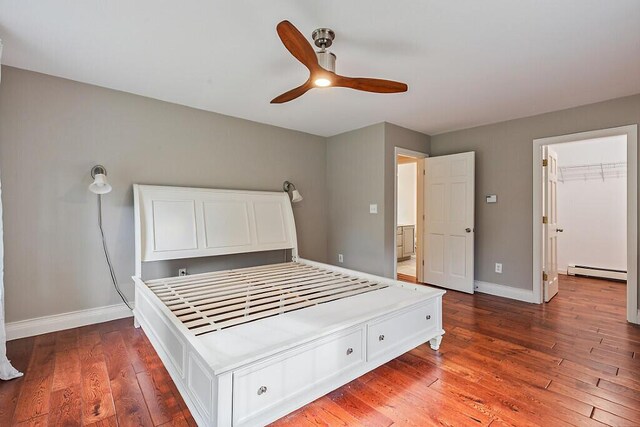4 Acorn Ln, Lewiston, ME 04240 - unfurnished bedroom featuring baseboard heating, wood-type flooring, ceiling fan, and a spacious closet