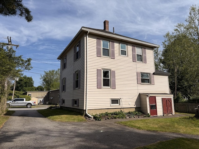 21 Peary Ter, South Portland, ME 04106 - view of home's exterior featuring a chimney and driveway