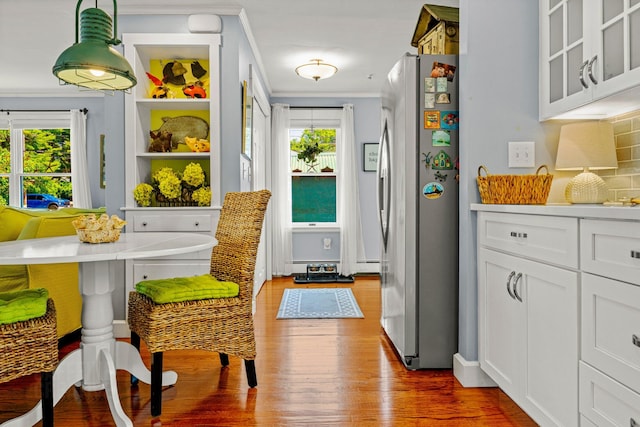 12 Fillmore Ave, South Portland, ME 04106 - kitchen with freestanding refrigerator, wood finished floors, ornamental molding, plenty of natural light, and light countertops