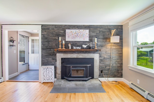 1 Madison St, Augusta, ME 04330 - unfurnished living room with a baseboard radiator, hardwood / wood-style flooring, ornamental molding, and a wood stove