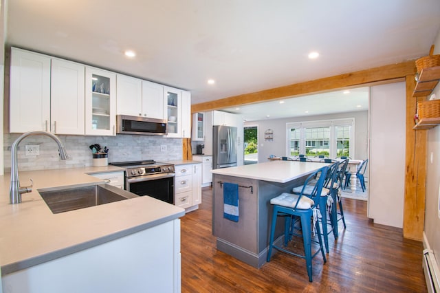 1 Madison St, Augusta, ME 04330 - kitchen with appliances with stainless steel finishes, tasteful backsplash, recessed lighting, dark wood-style flooring, and a kitchen bar