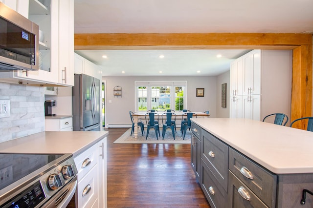 1 Madison St, Augusta, ME 04330 - kitchen featuring stainless steel appliances, white cabinetry, beam ceiling, dark wood-style floors, and light countertops