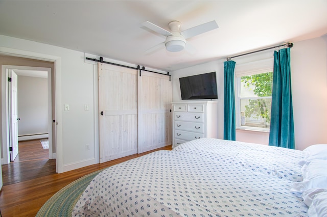 1 Madison St, Augusta, ME 04330 - bedroom with a barn door, a baseboard heating unit, wood finished floors, and a ceiling fan