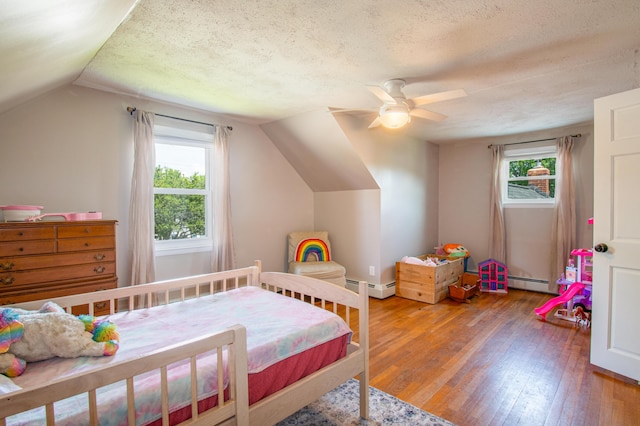 1 Madison St, Augusta, ME 04330 - bedroom featuring hardwood / wood-style flooring, multiple windows, lofted ceiling, a textured ceiling, and baseboard heating