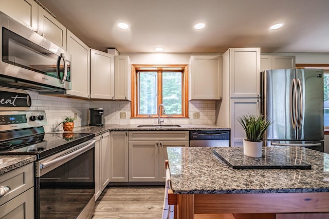 375 Gorham Rd, Scarborough, ME 04074 - kitchen featuring stainless steel appliances, light wood-style floors, dark stone countertops, recessed lighting, and backsplash
