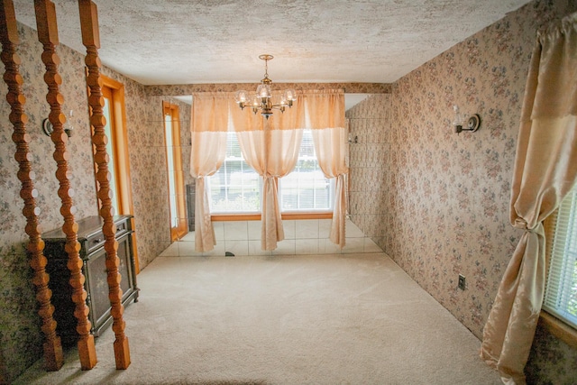142 Military Rd, Greenbush, ME 04418 - unfurnished dining area with wallpapered walls, carpet floors, a chandelier, healthy amount of natural light, and a textured ceiling