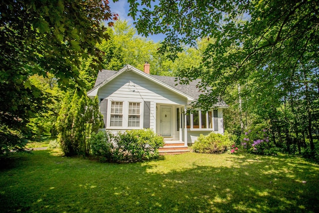 142 Military Rd, Greenbush, ME 04418 - bungalow with a front yard, a shingled roof, and a chimney