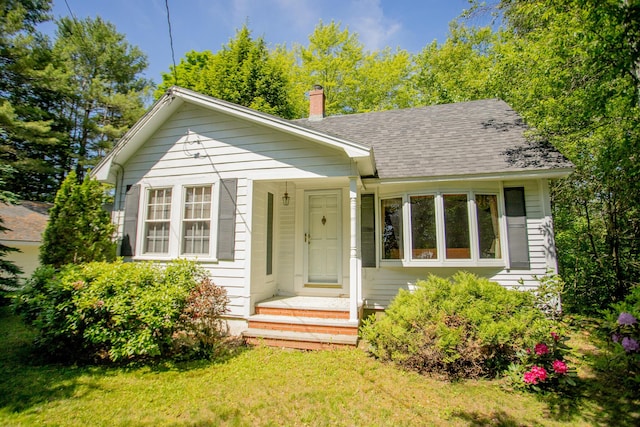 142 Military Rd, Greenbush, ME 04418 - bungalow with a chimney, a front yard, and a shingled roof