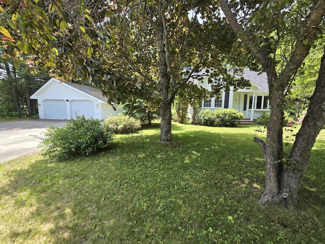142 Military Rd, Greenbush, ME 04418 - view of grassy yard featuring a garage and concrete driveway
