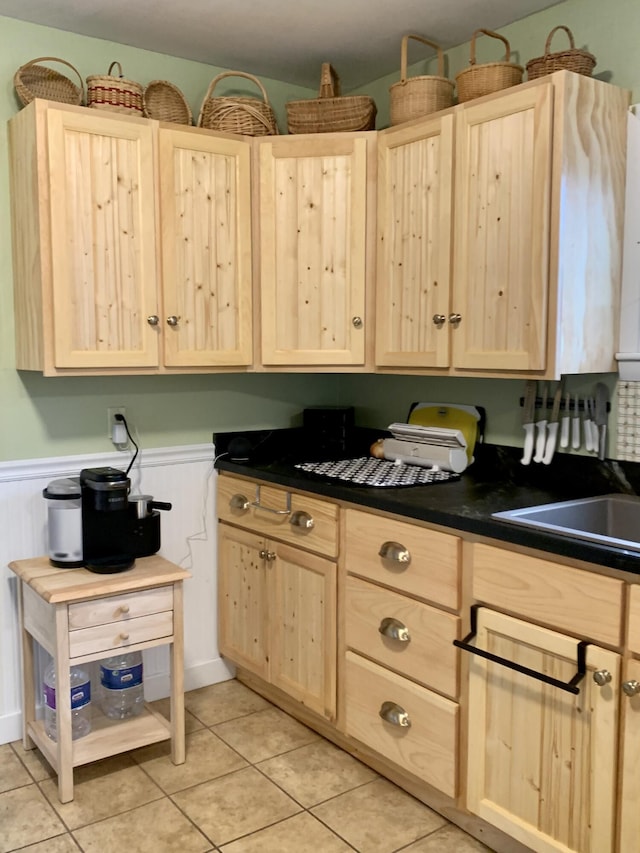 361 Water St, Addison, ME 04606 - kitchen featuring light brown cabinetry, a wainscoted wall, dark countertops, and light tile patterned flooring