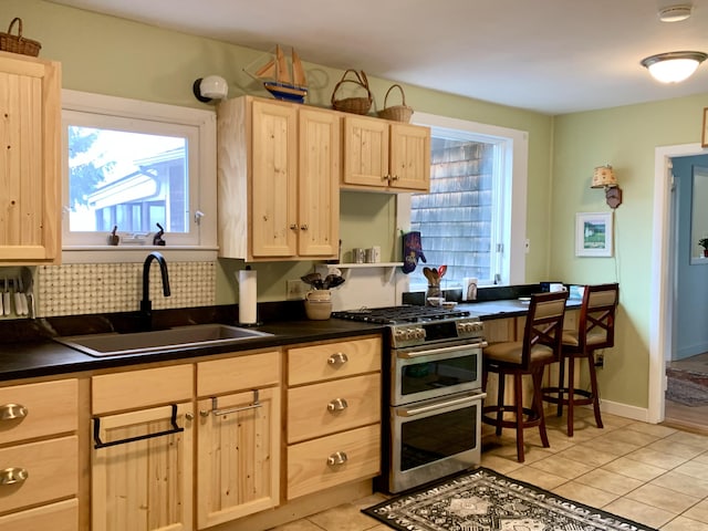 361 Water St, Addison, ME 04606 - kitchen with light brown cabinets, range with two ovens, dark countertops, light tile patterned floors, and open shelves
