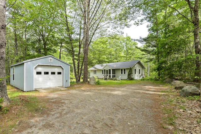 17 Eagle Ln, Damariscotta, ME 04543 - view of front facade with driveway, a detached garage, an outdoor structure, and view of scattered trees