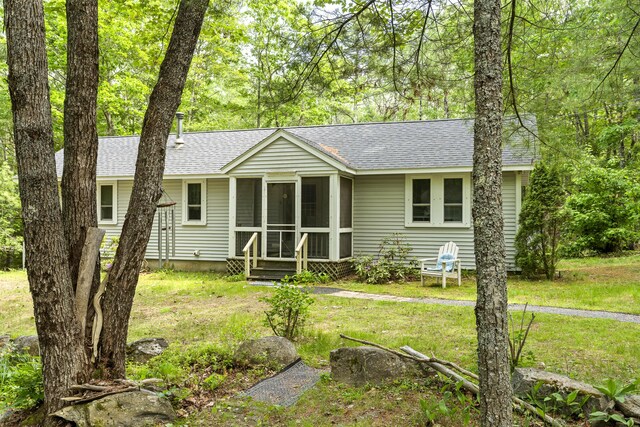17 Eagle Ln, Damariscotta, ME 04543 - ranch-style house featuring roof with shingles, a sunroom, and a front lawn