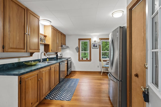 17 Eagle Ln, Damariscotta, ME 04543 - kitchen featuring stainless steel appliances, light wood-style flooring, dark countertops, under cabinet range hood, and open shelves