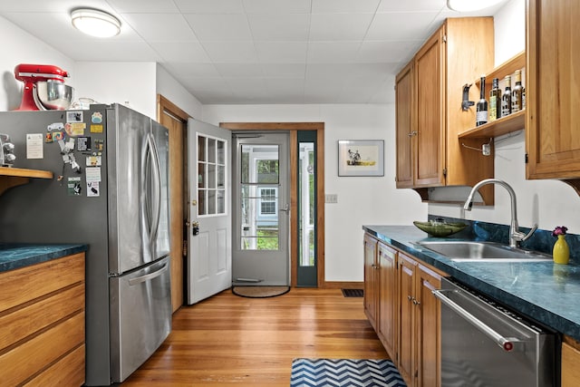 17 Eagle Ln, Damariscotta, ME 04543 - kitchen featuring appliances with stainless steel finishes, dark countertops, light wood-style floors, and brown cabinets