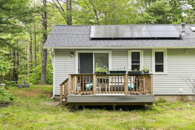 17 Eagle Ln, Damariscotta, ME 04543 - rear view of house featuring roof with shingles, a wooden deck, and roof mounted solar panels
