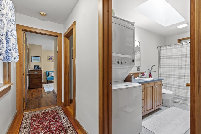 17 Eagle Ln, Damariscotta, ME 04543 - laundry area featuring stacked washer / dryer, a skylight, and light wood-type flooring