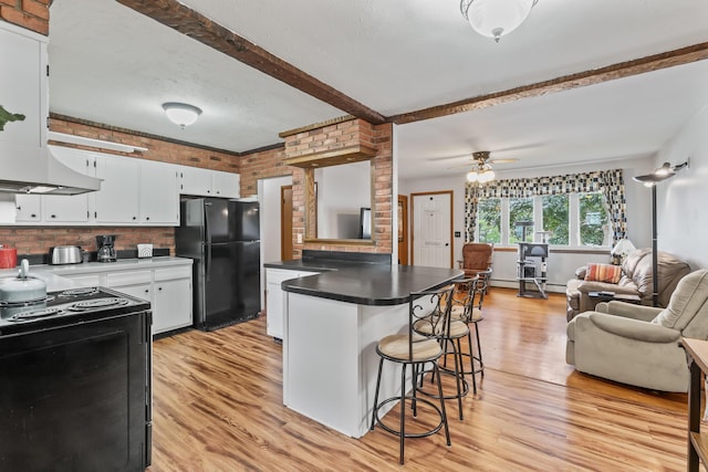 8 Grovemount Ln, Lewiston, ME 04240 - kitchen with black appliances, open floor plan, light wood-type flooring, a breakfast bar area, and beamed ceiling