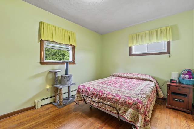 8 Grovemount Ln, Lewiston, ME 04240 - bedroom with a baseboard heating unit and wood finished floors
